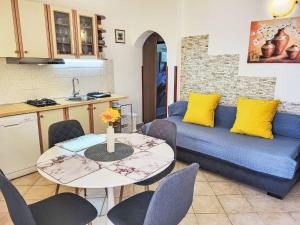 eine Küche und ein Wohnzimmer mit einem Tisch und einem Sofa in der Unterkunft Holiday Home Ive by Interhome in Petrcane