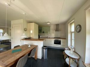 a kitchen with a wooden table and a counter top at Holiday Home Wiringherlant-2 by Interhome in Noordstroe +17 photos