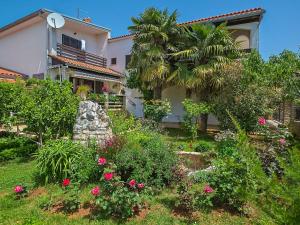 a garden in front of a house with a palm tree at Apartment Danica-1 by Interhome in Peroj