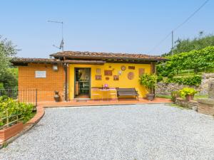a yellow house with a bench and a table at Holiday Home Al Melo by Interhome in San Gennaro