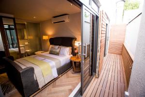 a bedroom with a bed on a wooden deck at Collection Luxury Accommodation Oudehoek Apartments in Stellenbosch