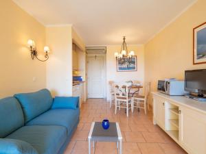 ein Wohnzimmer mit einem blauen Sofa und einem Tisch in der Unterkunft Apartment Les Calanques Spa Thalassothérapie-4 by Interhome in Les Issambres