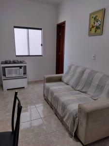 a living room with a couch and a microwave at Residencial Carvalho Ap 4 in Torto