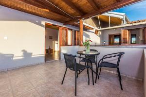 a table and chairs on a patio with a bar at Apartments Draga in Sukošan