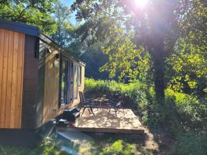 una casa con tavolo e sedie su una terrazza di Holiday Home Tiny Haus Soul & Forest by Interhome a Wemding