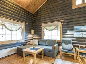 列维Holiday Home Mötönpesä 2 by Interhome的客厅里有一张沙发、一张桌子和两扇窗户