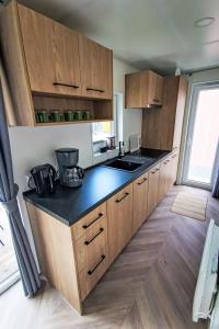 a kitchen with wooden cabinets and a black counter top at Holiday Home Tiny Haus Christas Angler-Oase by Interhome in Riedenburg