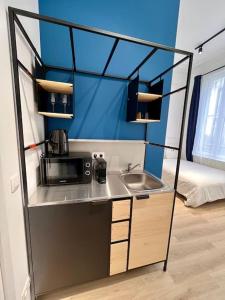 a small kitchen with a sink and a microwave at Chez Gianni & Stéphanie - A cozy and elegant Studio in Brussels in Brussels