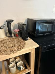 a microwave sitting on top of a table with cups at Townhouse room heerenhuys in Eeklo +7 photos