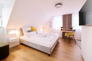 a bedroom with a large white bed and a desk at Xzllenz - 4 Schlafzimmer, Zentral, Parken, U-Bahn, 2 Bäder, 4 Smart-TV, optional Einzelbett in Nürnberg
