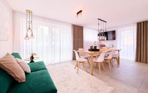 a living room with a green couch and a table at Xzllenz - 4 Schlafzimmer, Zentral, Parken, U-Bahn, 2 Bäder, 4 Smart-TV, optional Einzelbett in Nürnberg
