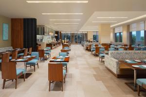 a dining room with tables and chairs in a restaurant at Fairfield by Marriott Jodhpur in Jodhpur