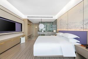 Un pat sau paturi într-o cameră la New Century Mansion Hotel Cixi Guanhaiwei
