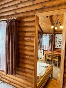 a room with a wooden wall with a bed and a table at Útulný srub na jihu Brna in Želešice +16 photos