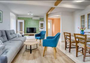 Apartment with sea view في أوباتيا: غرفة معيشة مع أريكة وكراسي وطاولة