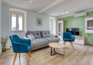 Apartment with sea view في أوباتيا: غرفة معيشة مع أريكة وكرسيين +صورة واحدة