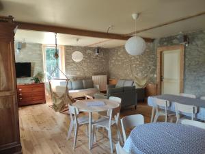 a living room with tables and chairs and a couch at Gîte Le Lustou in Cadéac