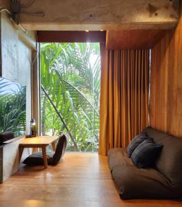 a living room with a couch and a table at hiddenwoods in Bang Chak