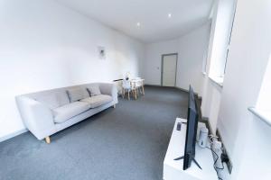 a living room with a white couch and a tv at Contemporary 1 Bed Apartment in Blackburn Centre in Blackburn +7 photos