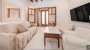 a living room with two couches and a tv at Can Raixa in Lloseta