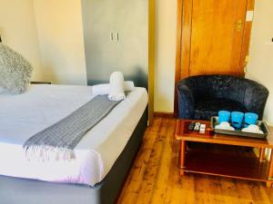 a bedroom with a bed and a chair and a table at Chapman Guesthouse in Pelham