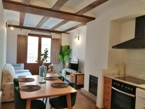 a kitchen with a table and chairs in a room at Apartamentos Casa Memé in Mora de Rubielos