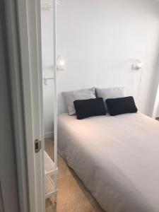 a white bed with two pillows in a room at A 50 m de la plage in Cullera