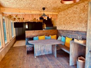 a dining area with a table and benches in a room at Domaine de la Planche de Melussac in Cussac-sur-Loire