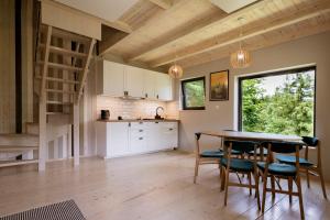 a kitchen and dining room with a table and chairs at Slow Huts in Miedzygorze