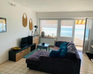 a living room with a couch and a tv at Traumferienwohnung222 in Neustadt in Holstein
