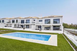 an exterior view of a house with a swimming pool at Almancil Elegant Villa With Pool by Homing in Almancil