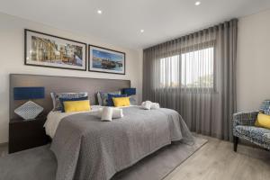 a bedroom with a bed with yellow and blue pillows at Almancil Elegant Villa With Pool by Homing in Almancil +12 photos