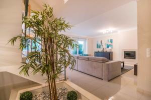a living room with a couch and a palm tree at Portimao Elegant House With Pool by Homing in Portimão