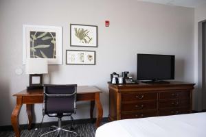 a bedroom with a desk with a television and a bed at Country Inn & Suites by Radisson, BWI Airport Baltimore , MD in Linthicum Heights +37 photos