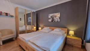 een slaapkamer met een groot bed en een spiegel bij Hortensia -213- in Mittenwald