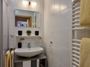 een witte badkamer met een wastafel en een spiegel bij Hortensia -213- in Mittenwald +11 foto's