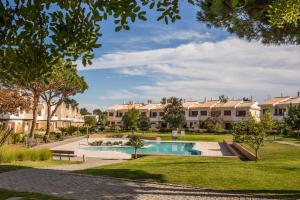 a courtyard with a swimming pool and apartment buildings at Vilamoura Typical 3 With Pool by Homing in Quarteira