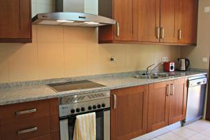 een keuken met een fornuis en een spoelbak bij Vilamoura Typical 3 With Pool by Homing in Quarteira +13 foto's