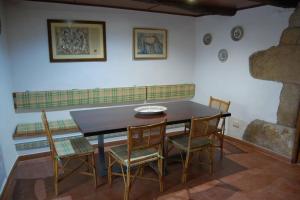 a dining room with a wooden table and chairs at A Casa do Buxo in Casardeita