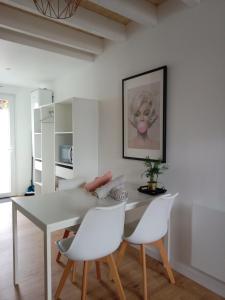 ein Esszimmer mit einem weißen Tisch und weißen Stühlen in der Unterkunft "Studiocaroline44", 2 studios entre la ville et la mer, parking, cuisine, moins de 15min de l'aéroport in Bouaye