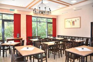 a dining room with tables and chairs and windows at Landhotel-Neunburg in Neunburg vorm Wald