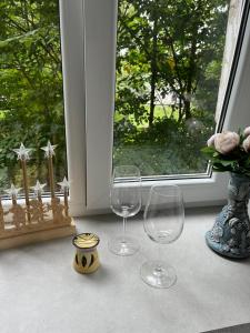 two wine glasses sitting on a table next to a window at Dzīvoklis īstermiņā in Liepāja