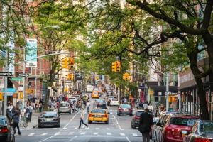 a busy city street with cars and people crossing the street at Comfortable Apartment with Workstation in New York