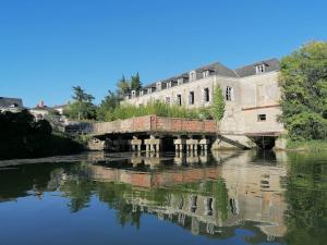 a bridge over a river in front of a building at La Casa del Rio in Durtal