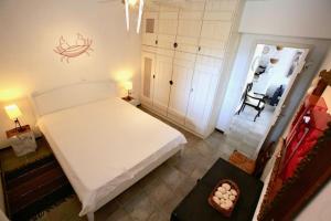 a bedroom with a large white bed and a chair at Thalassa Beach House - Kea Villa Rent - Kastellakia Bay Villas in Pisses