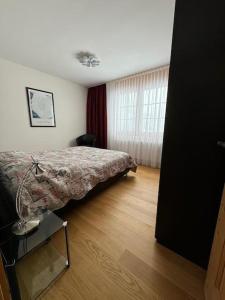 ein Schlafzimmer mit einem Bett und einem Holzboden in der Unterkunft Design Flat Davos in Davos
