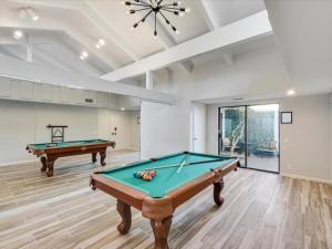 a room with two pool tables in it at West Irving Palace Miami Style in Irving