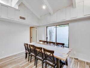 a dining room with a wooden table and chairs at West Irving Palace Miami Style in Irving