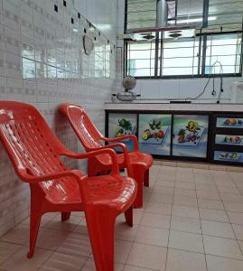 a row of red chairs in a restaurant at HAPPY HOMESTAY Lukut NS in Port Dickson