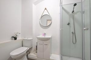 a white bathroom with a toilet and a mirror at Urban Nest Apartments Szewska 21-R in Kraków